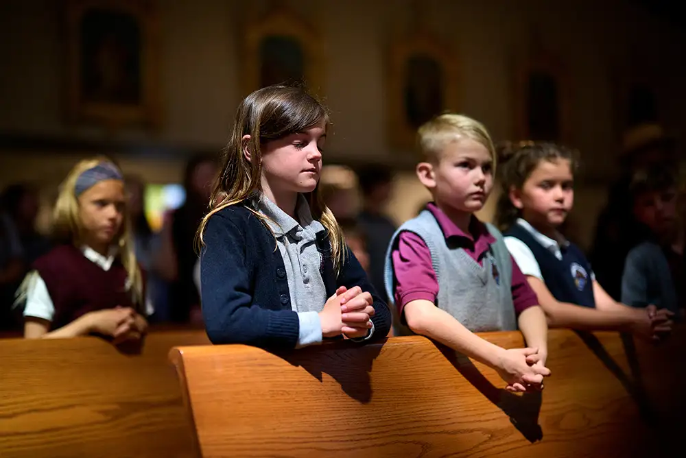Students praying at mass